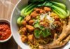 Resep Mie Ayam Homemade yang Bikin Kangen Abang-Abang Gerobak Mangkuk mie ayam kaya rasa ini menyajikan ayam crispy, sayuran segar, dan sambal pedas sebagai pelengkap yang menggugah selera.